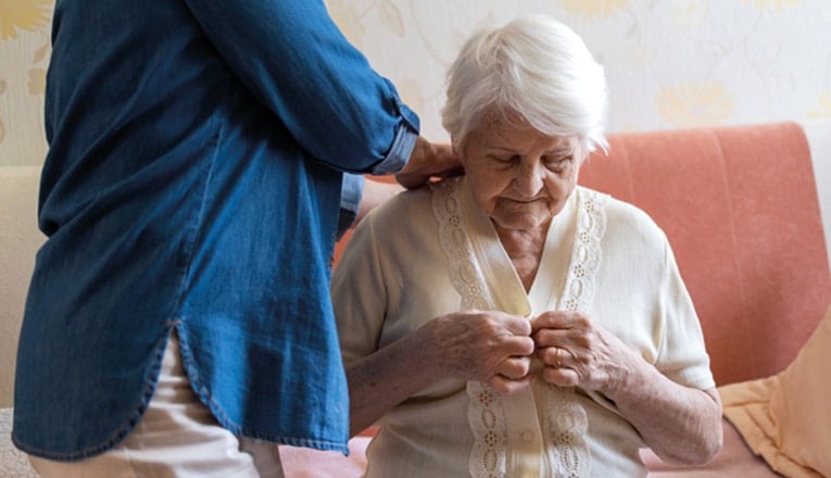 Thuiszorg voor ouderen bestaat vaak uit persoonlijke verzorging zoals helpen met aankleden.