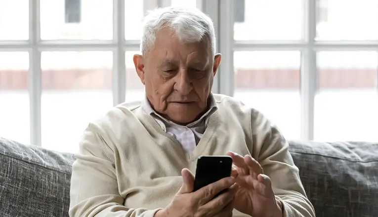 Meneer gebruikt zijn telefoon om de verwarming te bedienen