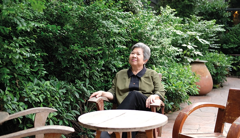 De oudere mevrouw woont veilig thuis en kan daarom langer van haar tuin genieten