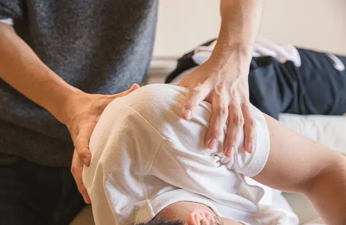 Een kinesist behandelt een man met symptomen van spierdystrofie