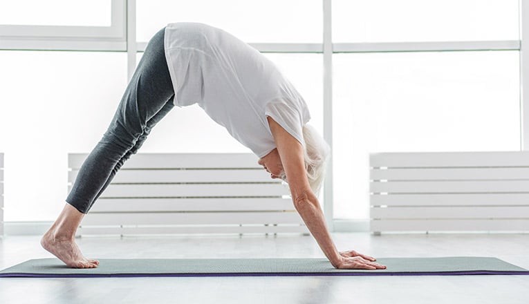 Une femme âgée fait des exercices pour avoir un meilleur équilibre.