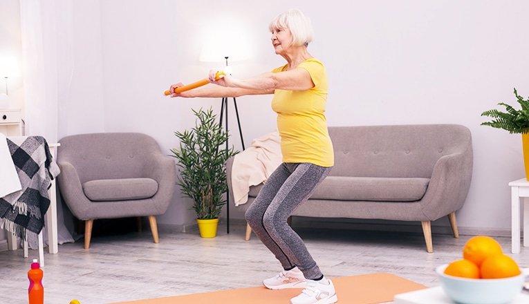 Une femme d'un certain âge effectue des squats comme exercice de fitness.